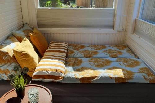 een bed in de hoek van een kamer met een raam bij Tiny House an den Bentheimer Klippen in Bad Bentheim