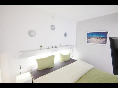 een witte slaapkamer met een bed met 2 kussens bij NEU! FeWo Panoramablick Hohegeiß Pool und Sauna in Hohegeiß
