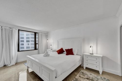 Un dormitorio blanco con una gran cama blanca y una ventana en Cozy Ocean View Condo Beach Service 1015, en Miami Beach