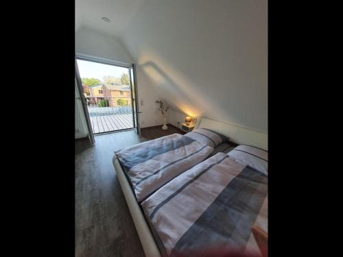 a bed in a room with a large window at NEU! Ferienhaus 54 Husum inkl Sauna in Husum