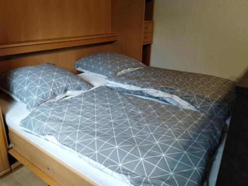 a bed with two pillows on top of it at NEU! Sommerhaus im Cuxland in Hechthausen