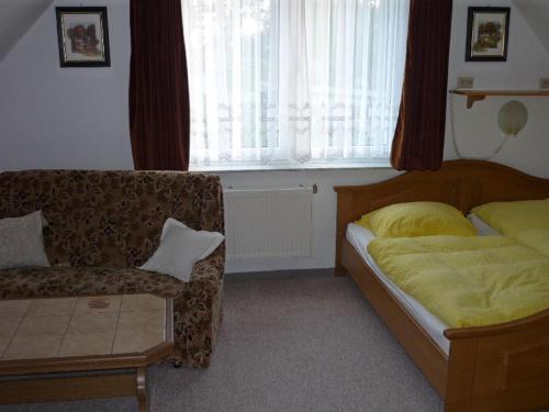 a bedroom with a bed and a couch and a window at NEU Ferienwohnung Storchennest OG in Kramerhof