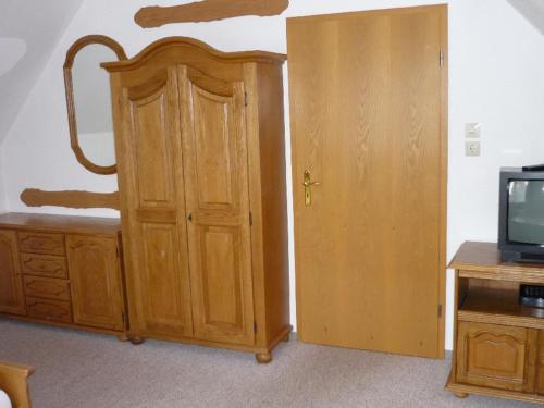 a room with a wooden cabinet and a tv at NEU Ferienwohnung Storchennest OG in Kramerhof