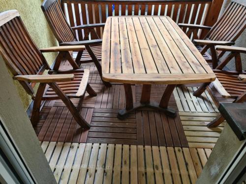 a wooden picnic table and two chairs on a deck at NEU! Ferienwohnung in Mücheln mit Balkon in Mücheln