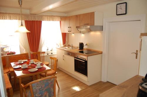 a kitchen and dining room with a table and a kitchen gmaxwell gmaxwell gmaxwell at NEU! Ferienhaus Johann an der Nordsee in Dornum