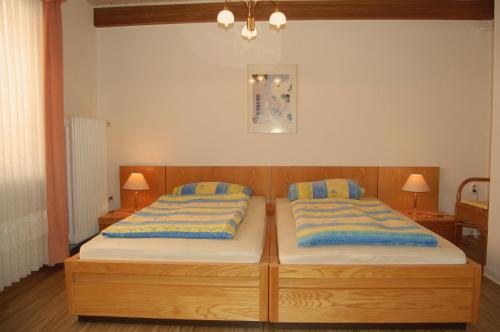 2 camas individuales en una habitación con 2 lámparas en NEU! Ferienhaus Johann an der Nordsee, en Dornum