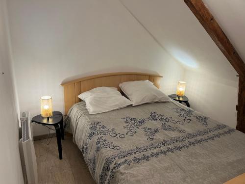 ein Schlafzimmer mit einem Bett mit zwei Nachttischen in der Unterkunft Gîte de la Haie des Bois - 8P in Plessé
