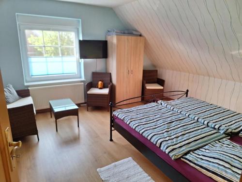 1 dormitorio con 1 cama, 1 silla y 1 ventana en NEU! Ferienhaus Wattentraum mit Sauna, en Dornum