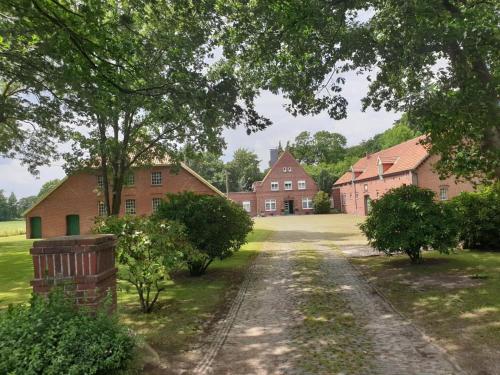 a dirt road in front of a large brick house at NEU Küstenliebe Friesland in Varel