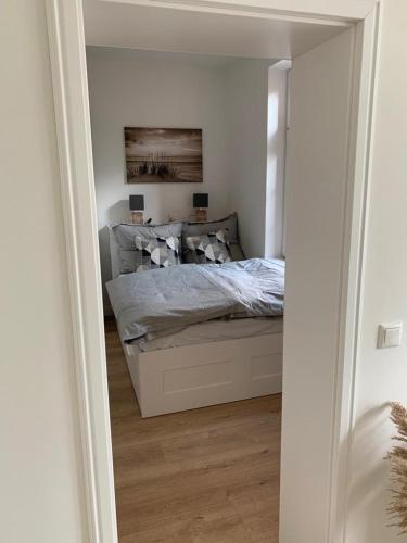 a bedroom with a bed in a white room at NEU Küstenliebe Friesland in Varel