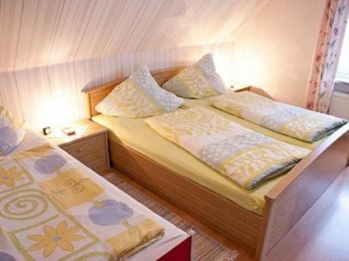 ein kleines Schlafzimmer mit 2 Betten und Kissen in der Unterkunft NEU! FeWo Deichblick 2 OG in Dornum