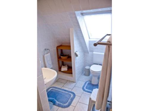 ein Bad mit einem Waschbecken, einem WC und einem Fenster in der Unterkunft NEU! FeWo Deichblick 2 OG in Dornum