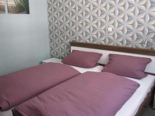 a bedroom with two beds with purple pillows at Ferienhaus am Rheinsteig in Kaub