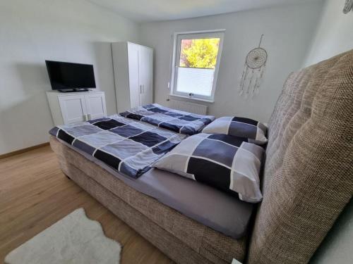 a bed in a room with a couch and a television at Ferienhaus Am Zollhaus in Teplingen