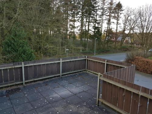 a wooden fence next to a road with trees at NEU Ferienwohnung Kropp OG - Rechts in Kropp