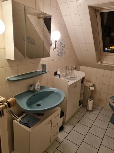 a bathroom with a green sink and a tub at NEU! Ferienwohnung zum Anker in Heeslingen