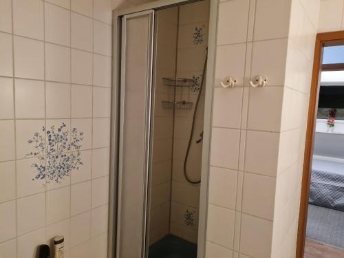 a shower in a bathroom with white tiles at NEU! Ferienwohnung zum Anker in Heeslingen