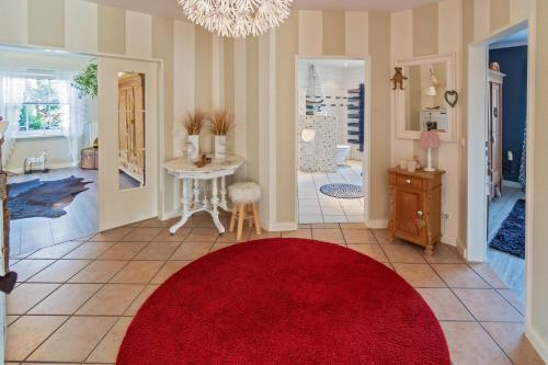 a living room with a red rug on the floor at NEU! Exklusives Ferienhaus Ella in Dornum