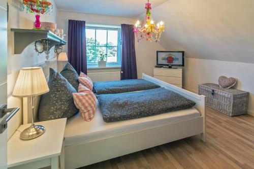 a bedroom with a bed and a chandelier at NEU! Exklusives Ferienhaus Ella in Dornum
