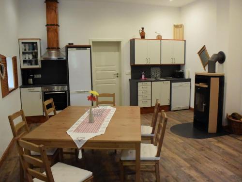 a kitchen with a wooden table with chairs and a kitchen with white cabinets at NEU! Moderne FeWo Nähe Plauer See in Preddöhl