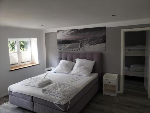 Un dormitorio con una cama con un cuadro en la pared. en Ferienhaus Kastanie mit Whirlpool Kamin und Sauna, en Blekendorf