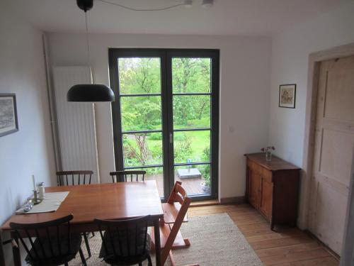 a dining room with a table and a large window at NEU! Ferienhaus mit Naturgarten in Gleschendorf