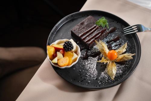 a plate of food with chocolate and fruit on a table at Szalajka Fogadó és Étterem in Szilvásvárad