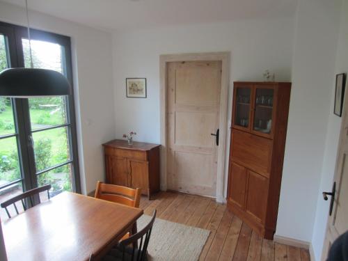 a dining room with a table and a door at NEU! Ferienhaus mit Naturgarten in Gleschendorf