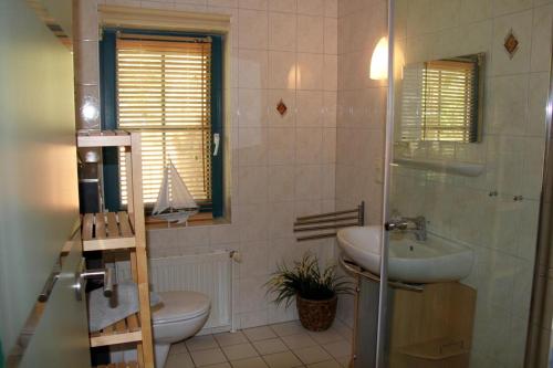 uma casa de banho com um lavatório, um WC e um chuveiro em NEU! FeWo Haubentaucher 600 Meter vom Strand em Prerow