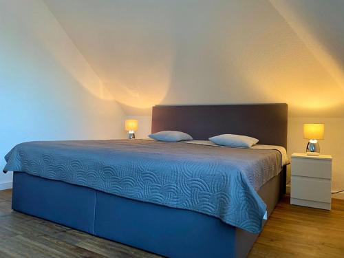 ヴァルスローデにあるNEU Ferienwohnung Walsrodeのベッドルーム1室(青いベッド1台、ランプ2つ付)