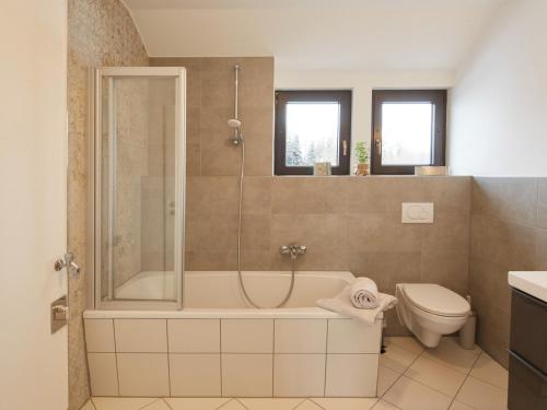een badkamer met een douche, een bad en een toilet bij NEU! Ferienwohnung im Gottesgarten am Obermain in Hochstadt am Main
