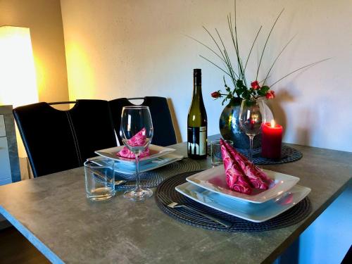 a table with two plates and a bottle of wine at NEU! Ferienwohnung Eulennest in Staudernheim