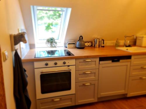 a kitchen with a stove and a sink and a window at NEU! Alte Schule Jarnsen Oberstübchen mit Balkon in Lachendorf