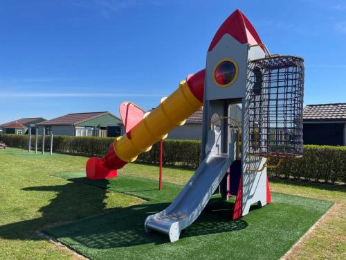 un parque infantil con tobogán y columpio en NEU! Ferienhaus Zijper 24, en Burgerbrug