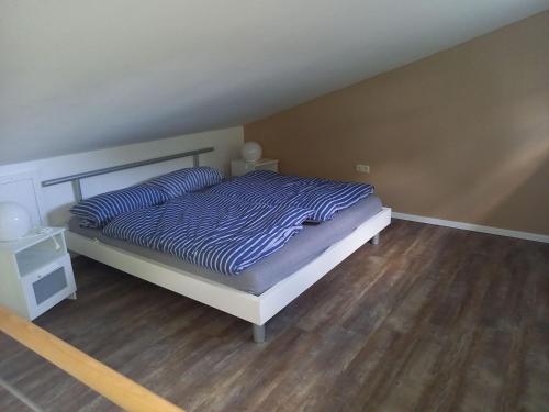 a bedroom with a bed and a wooden floor at NEU! Stylisches Ferienhaus an der Südheide in Scharnhorst