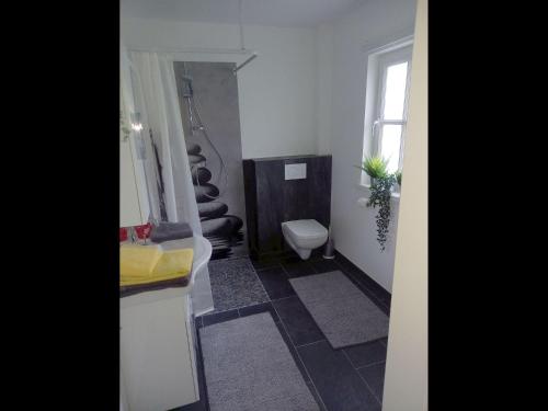 a bathroom with a toilet and a sink and a window at NEU! Stylisches Ferienhaus an der Südheide in Scharnhorst