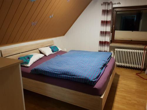 uma cama com um edredão azul num quarto em NEU! Ferienwohnung Ramke OG em Lilienthal