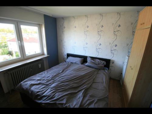 een kleine slaapkamer met een bed met 2 kussens erop bij NEU! Ferienwohnung im Herzen der Pfalz in Kaiserslautern