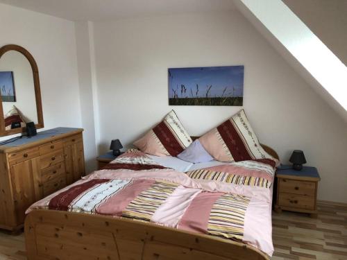 Un dormitorio con una cama y una cómoda en una habitación. en NEU Das Ferienhaus, en Dornumergrode