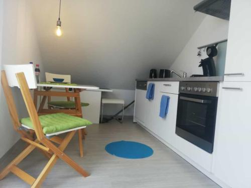 a kitchen with a stove and a table with a chair at NEU Modernes Appartment Lara 