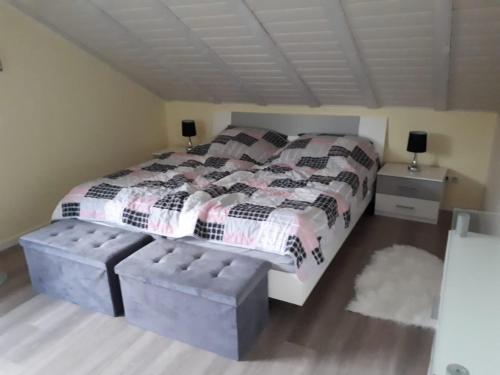 ein Schlafzimmer mit einem großen Bett und einem Fußbrett in der Unterkunft NEU Ferienwohnung Odenwald in Rimhorn
