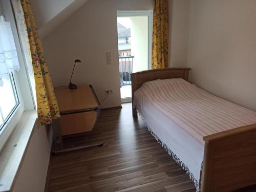 a bedroom with a bed and a desk and a window at NEU Ferienwohnung Biesfeld-Altes Backhaus in Kürten