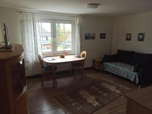 ein Wohnzimmer mit einem Tisch und einem Sofa in der Unterkunft NEU Ferienwohnung Biesfeld-Altes Backhaus in Kürten