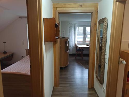 NEU Ferienwohnung Biesfeld-Altes Backhaus في Kürten: ممر يؤدي إلى غرفة نوم مع سرير وطاولة