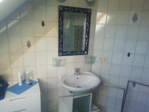 a white bathroom with a sink and a mirror at NEU! Ferienwohnung Nordfriesland in Achtrup