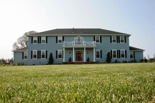 a blue house with a large field of grass at La Bastide Bed and Breakfast in Dundee