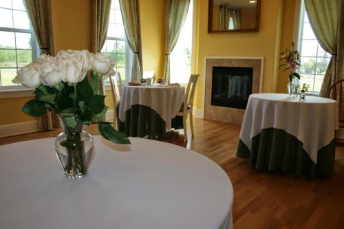 a vase of flowers on a table with two tables at La Bastide Bed and Breakfast in Dundee