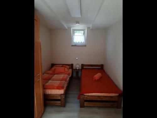 Duas camas num pequeno quarto com uma janela em NEU! Ferienwohnung Teichblick in Bad Grund em Bad Grund