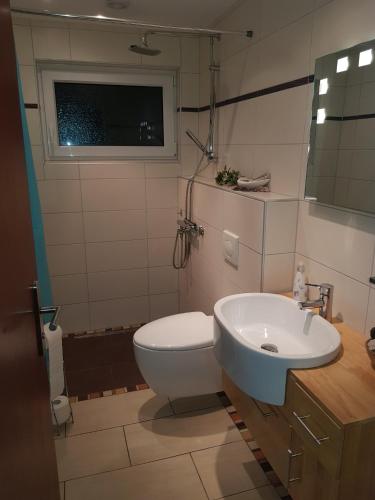 a bathroom with a white toilet and a sink at NEU! Ferienwohnung Ramke EG in Lilienthal