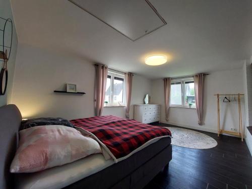 ein Schlafzimmer mit einem Bett und zwei Fenstern in der Unterkunft NEU Ferienwohnung Lottje in Dannewerk